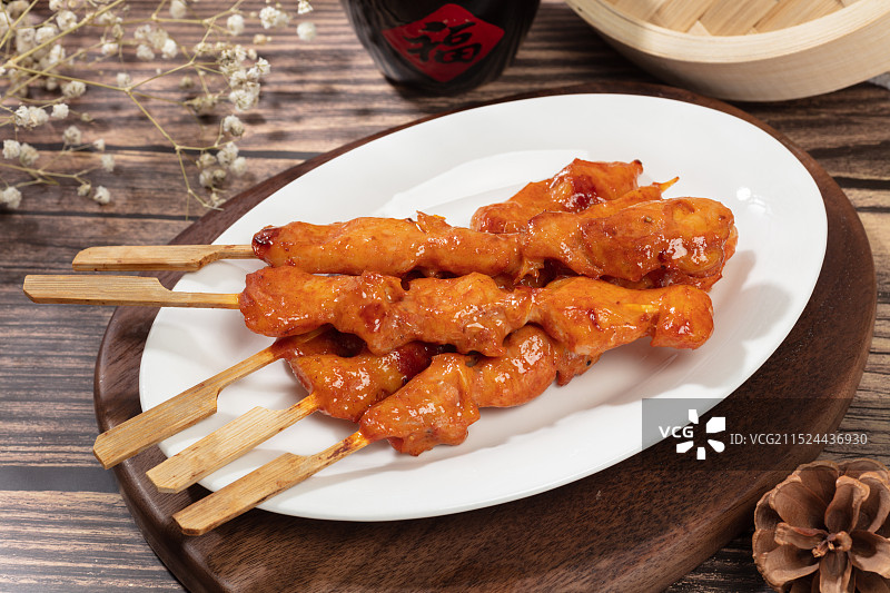 厚木板上摆放着一盘骨肉相连烤肉串图片素材