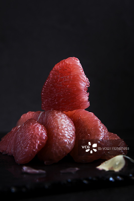 暗调背景下的红色柚子果肉特写图片素材