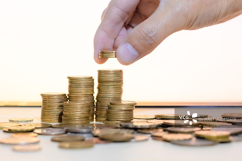 一个成年男人在堆放硬币图片素材