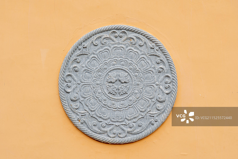 在黄色画墙上用石头制作的中国雕塑图片素材