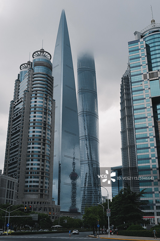 阴天云雾中的上海浦东陆家嘴摩天大楼低视角图片素材
