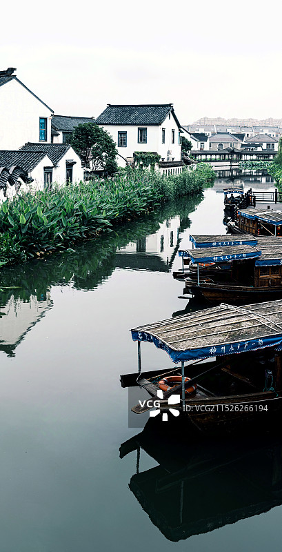 中国江苏苏州吴中甪直古镇江南水乡白墙黛瓦民居建筑与水面上的乌篷船倒影景观图片素材