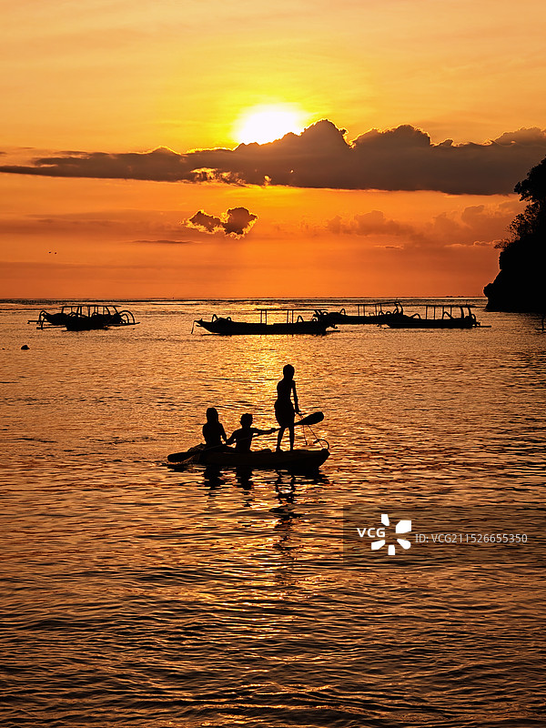日落剪影划船的孩子们图片素材