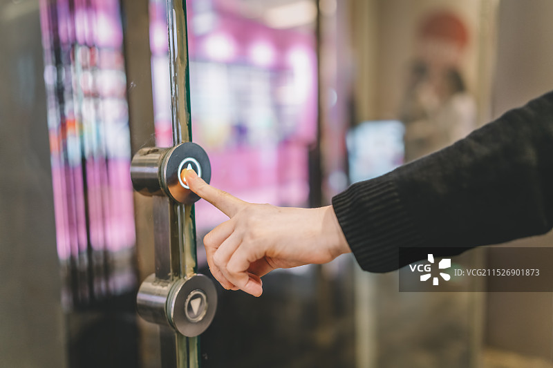 与自动门接触：一只手伸手去按按钮图片素材