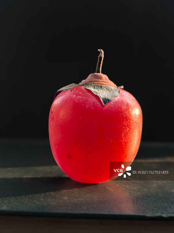 一只火红的灯笼柿子在夕阳下，红彤彤的非常鲜艳图片素材