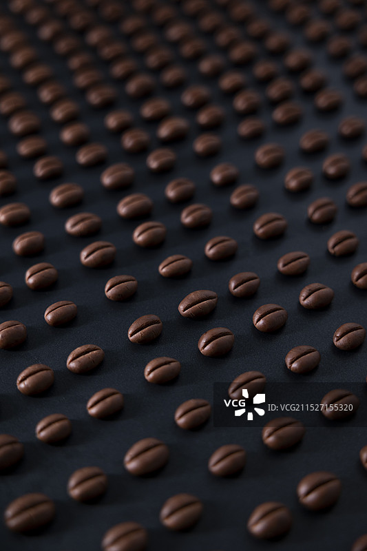 烤盘上排列整齐的手工咖啡豆饼干竖构图图片素材