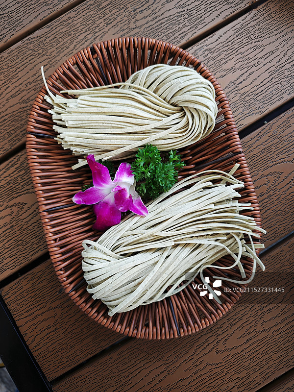 木桌上的面条和花朵图片素材