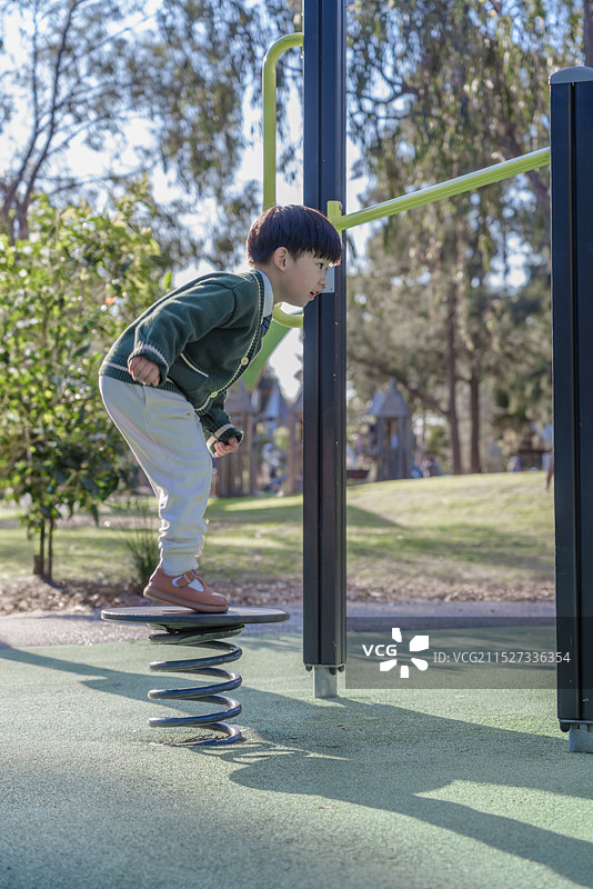 勇敢男孩尝试弹簧跳跃单杠肢体训练图片素材