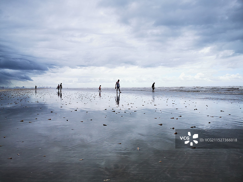 退潮海滩上赶海的人们图片素材
