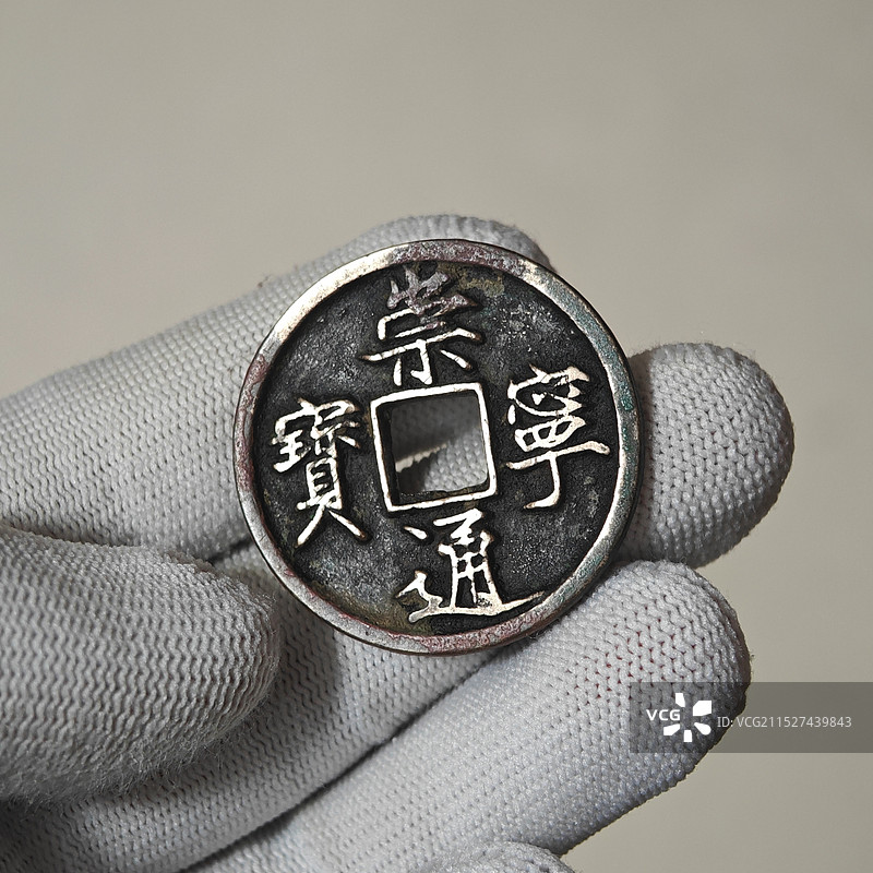 铜钱崇宁通宝宋朝北宋古钱币棉手套白手套特写图片素材