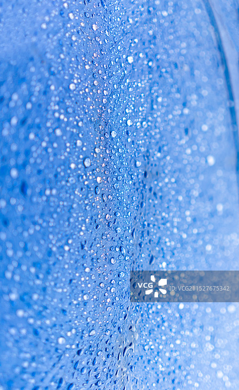 中国雨具拍摄主题，蓝色的雨伞防水布料上铺满了湿漉漉的透明的水珠雨水，户外白昼无人图像摄影图片素材