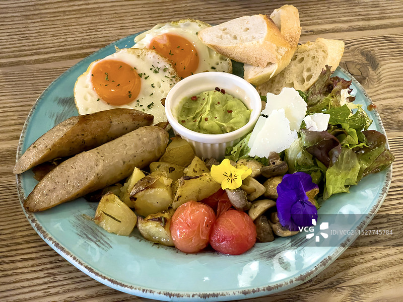 木质餐桌上品类丰富的大份西式早餐图片素材