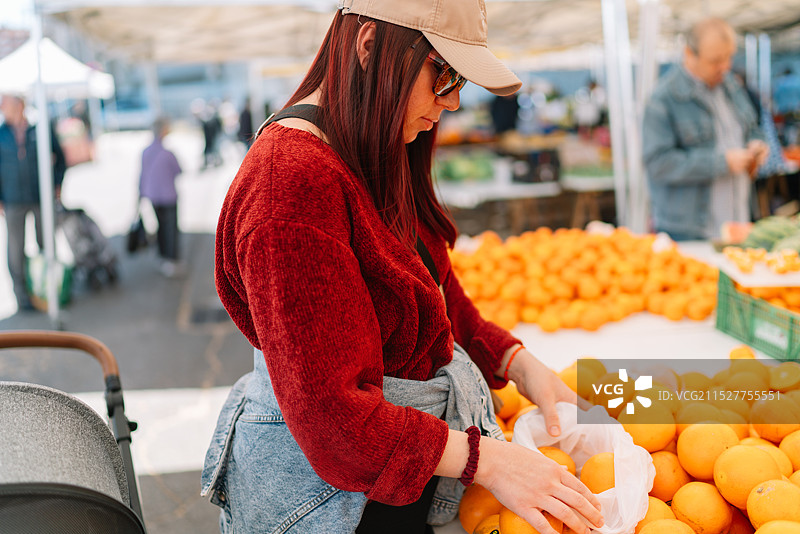 女人在市场上购买橙子图片素材