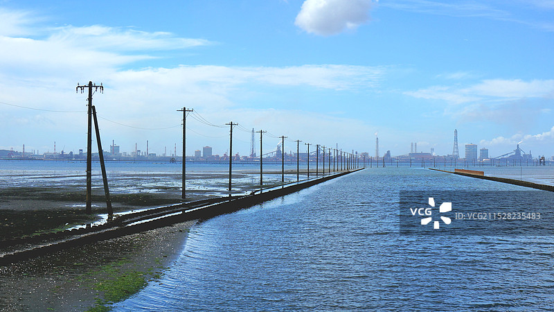 日本千叶县木更津市江川海岸，通向海中的电杆和远方的工厂图片素材