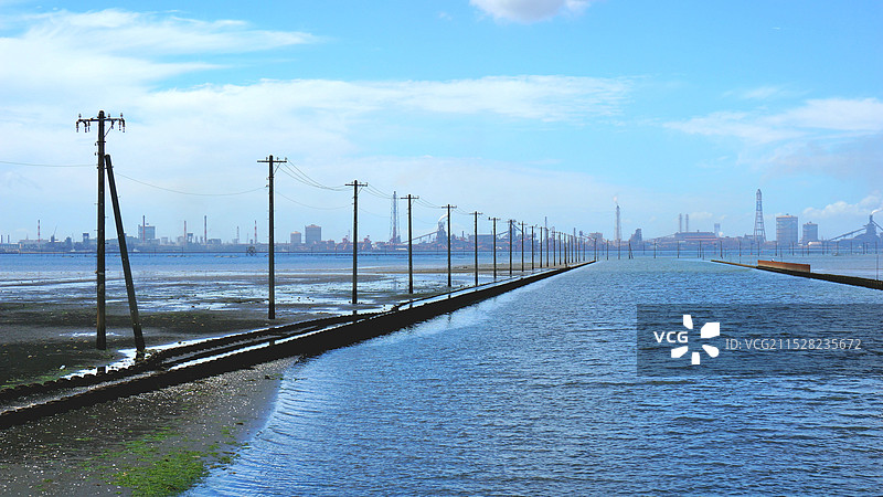 日本千叶县木更津市江川海岸，通向海中的电杆和远方的工厂图片素材
