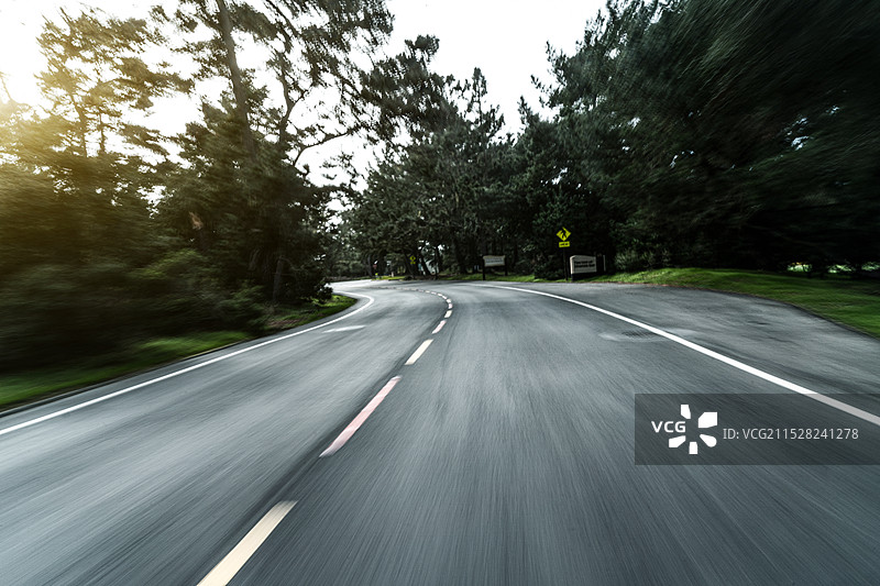 汽车穿过森林动感模糊的道路图片素材