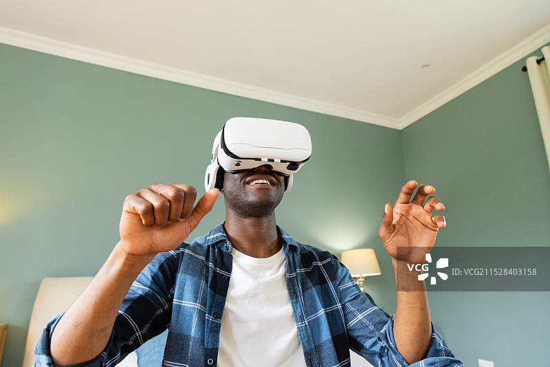 非裔美国男性在家中享受虚拟现实头戴设备的体验图片素材