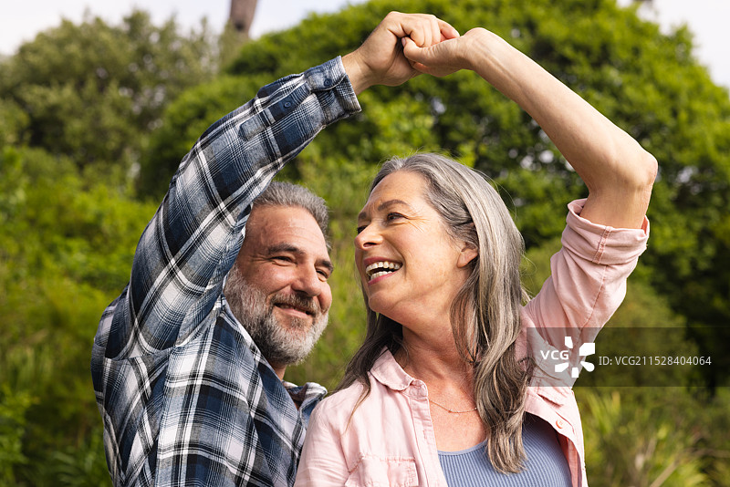 户外跳舞，成熟的情侣在阳光明媚的日子里快乐地享受时光图片素材
