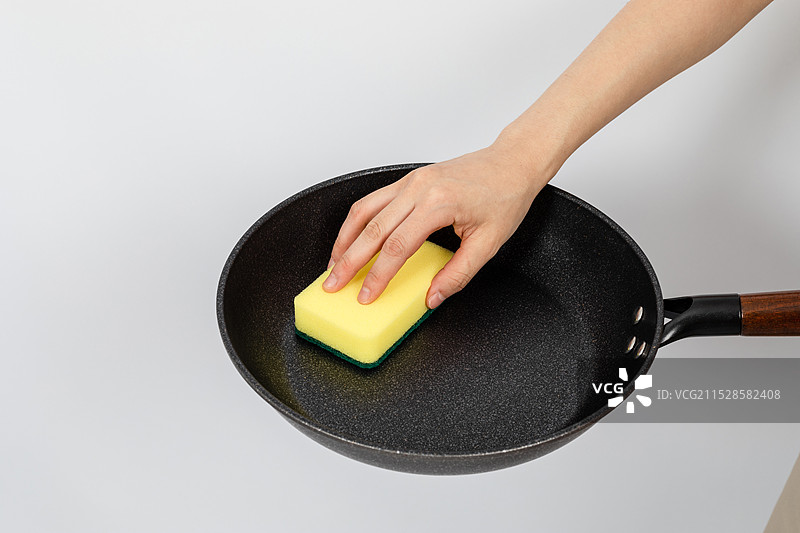女人用海绵百洁布清洁不粘锅图片素材