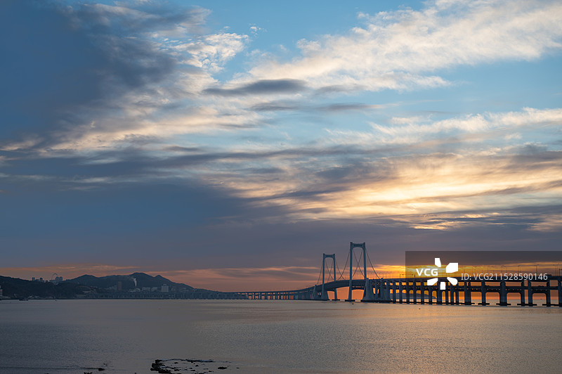 晨曦下的大连星海湾跨海大桥，夕阳下海天桥的剪影，朝霞下的跨海大桥海景景观，彩霞之下的大连跨海大桥海景图片素材