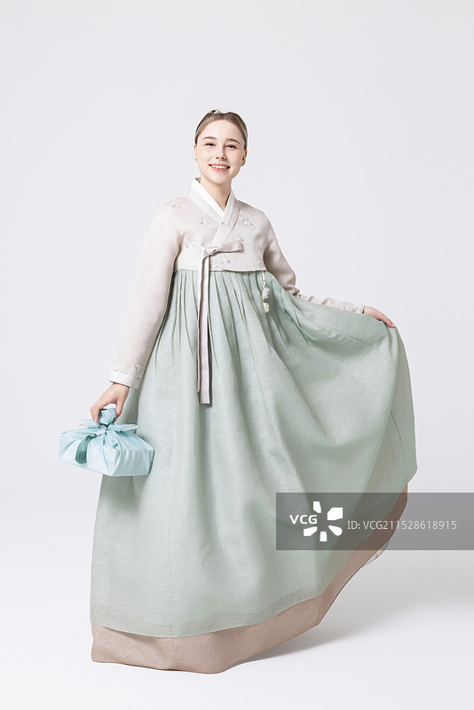 穿着韩服的西方女性手持用韩国风格包装的礼物图片素材