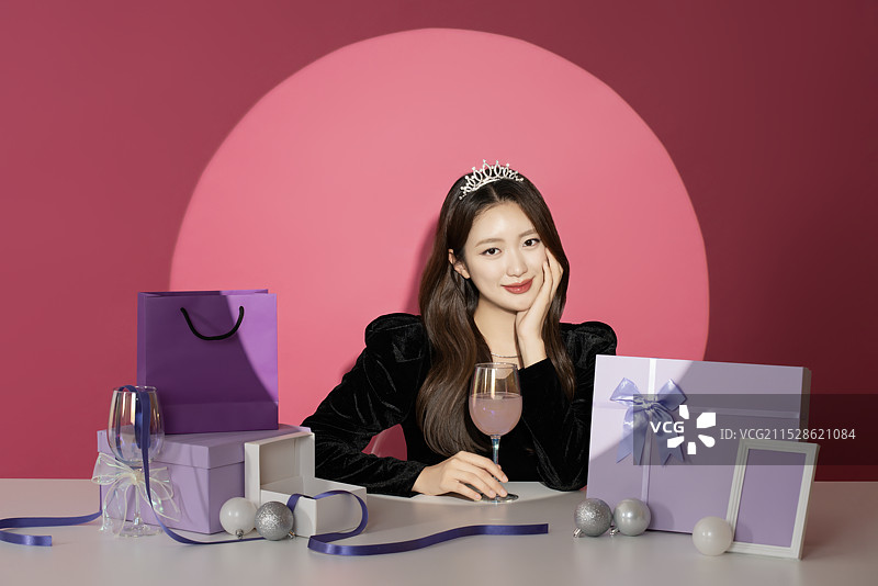 一位20多岁的女性主角在各种礼物面前受到关注和瞩目。图片素材