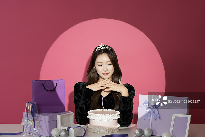 一位20多岁的女性主角在各种礼物面前受到关注和瞩目。图片素材