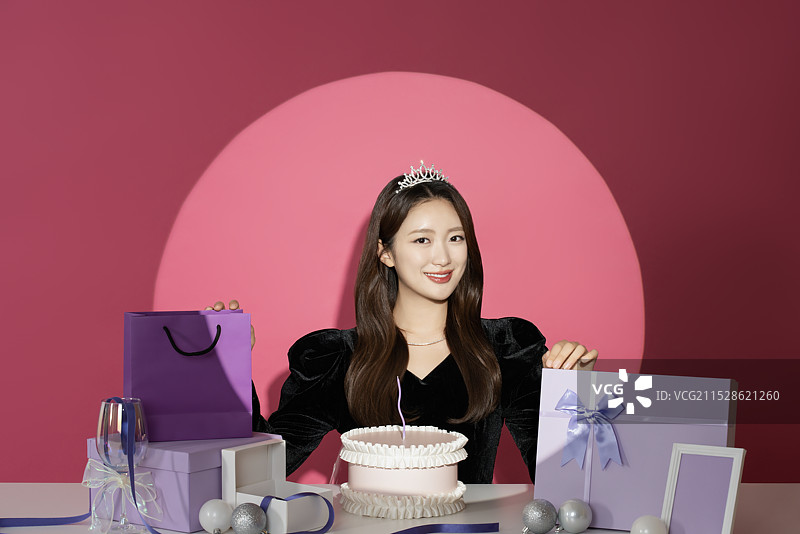 一位20多岁的女性主角在各种礼物面前受到关注和瞩目。图片素材