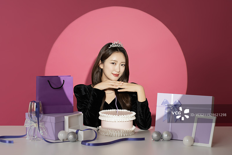 一位20多岁的女性主角在各种礼物面前受到关注和瞩目。图片素材