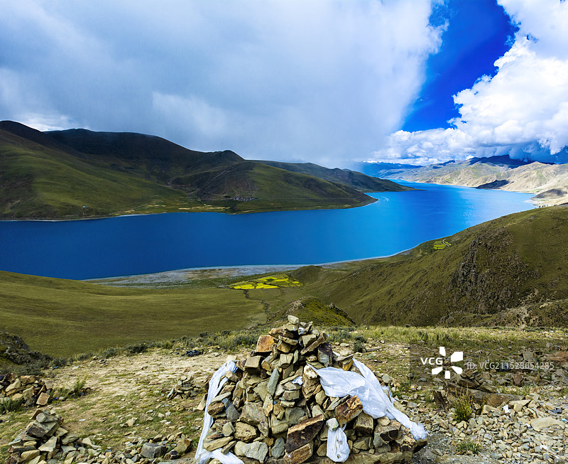 站在玛尼堆后面，远眺羊湖美景图片素材