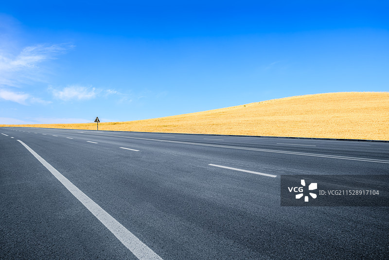 空旷的沥青道路和高原麦田风光图片素材