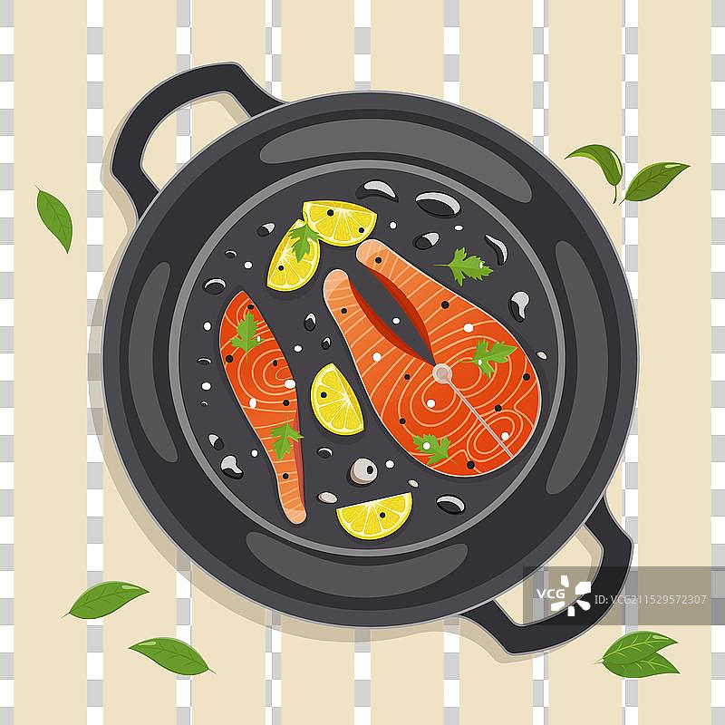 在煎锅中煎三文鱼排，配上柠檬片图片素材