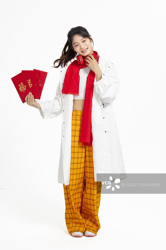 身着风衣拿着红包的年轻女人图片素材