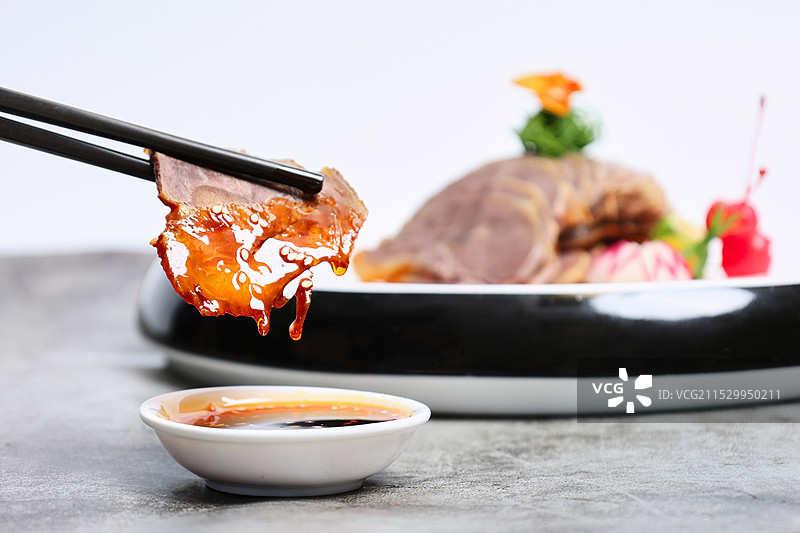 蘸取麻辣调料的美味卤牛肉图片素材