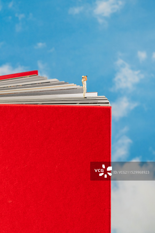 教育创意微缩景观 站在书本上眺望远方图片素材
