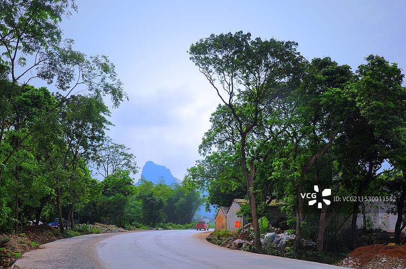 都安瑶台山庄的公路旁边的树木和远山图片素材
