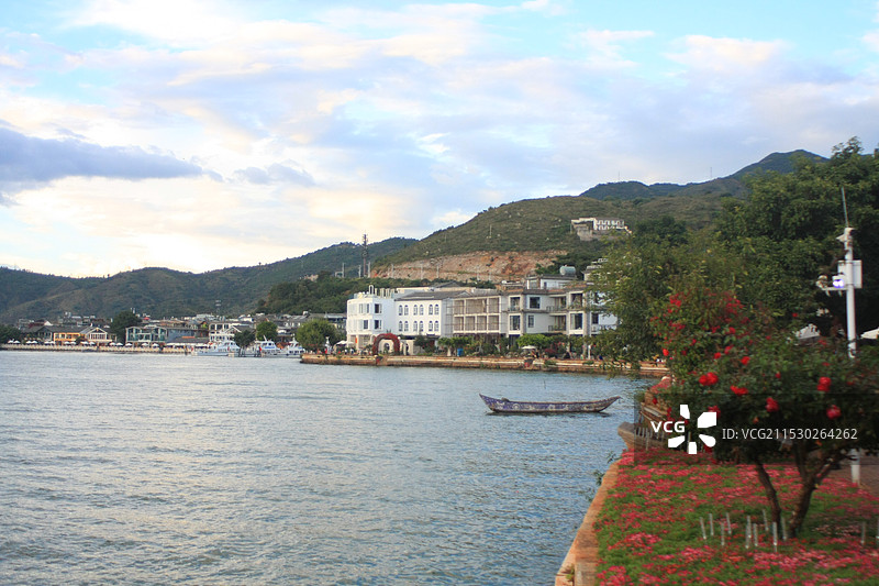大理双廊古镇的洱海边建筑和木船在蓝天白云下的特写图片素材