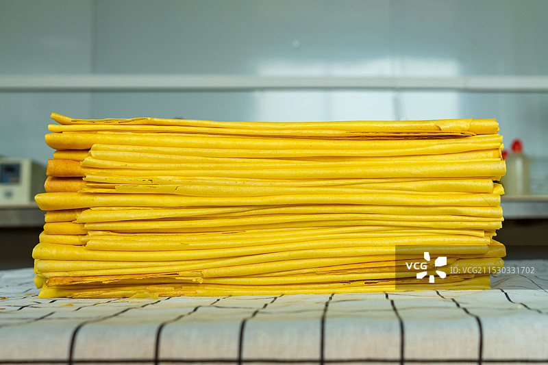 中国餐饮行业饮食产业，传统经典中国食品拍摄主题，折叠好的新鲜出炉的山东小米玉米煎饼，室内无人图像图片素材