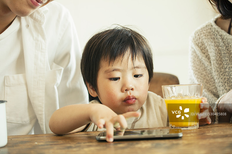 亲密的家庭在看智能手机图片素材