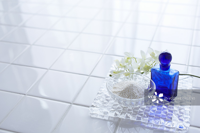 瓷砖上的浴盐和蓝色瓶子图片素材