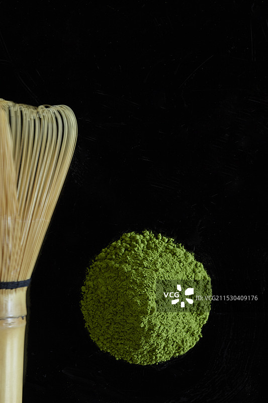 黑色背景上的抹茶粉和茶 whisk图片素材
