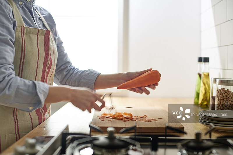 女人在厨房里削胡萝卜图片素材
