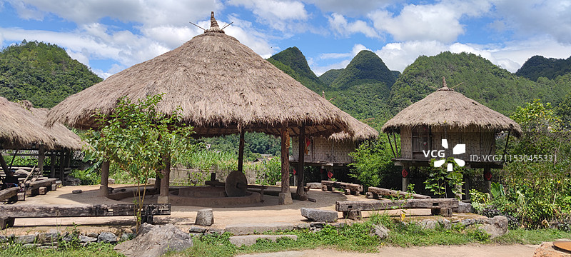 天空衬托下田野上房屋的全景照片图片素材