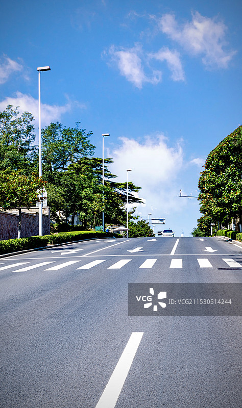蓝天白云下的山东青岛八大关山海道路公路.去往大海的方向图片素材