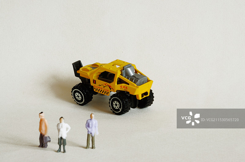 站在玩具越野车旁的彩色小人图片素材