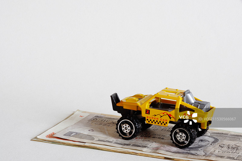 停放在货币上的玩具越野车图片素材