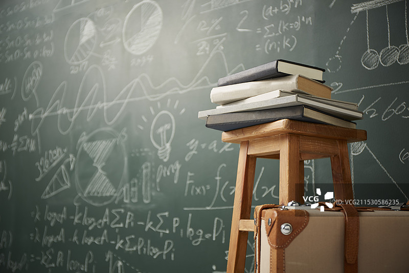 黑板前的椅子上堆放着书籍图片素材