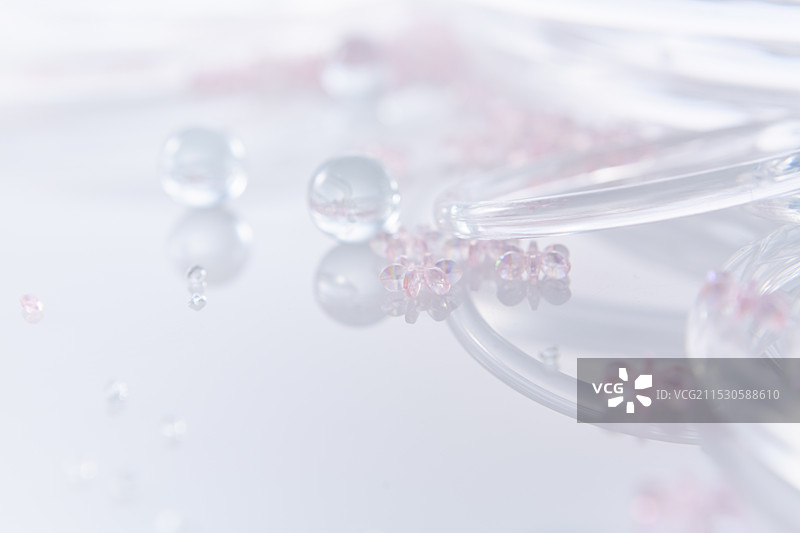 多个玻璃颗粒、玻璃球和玻璃环放置在反射板上图片素材