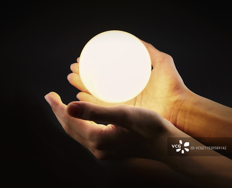 发光的灯泡和男人的手图片素材
