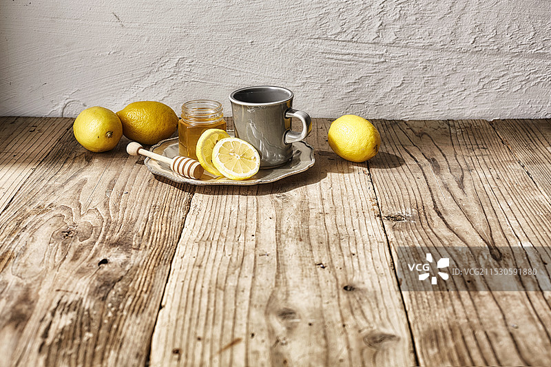 蜜色和灰色的杯子，周围放着柠檬图片素材